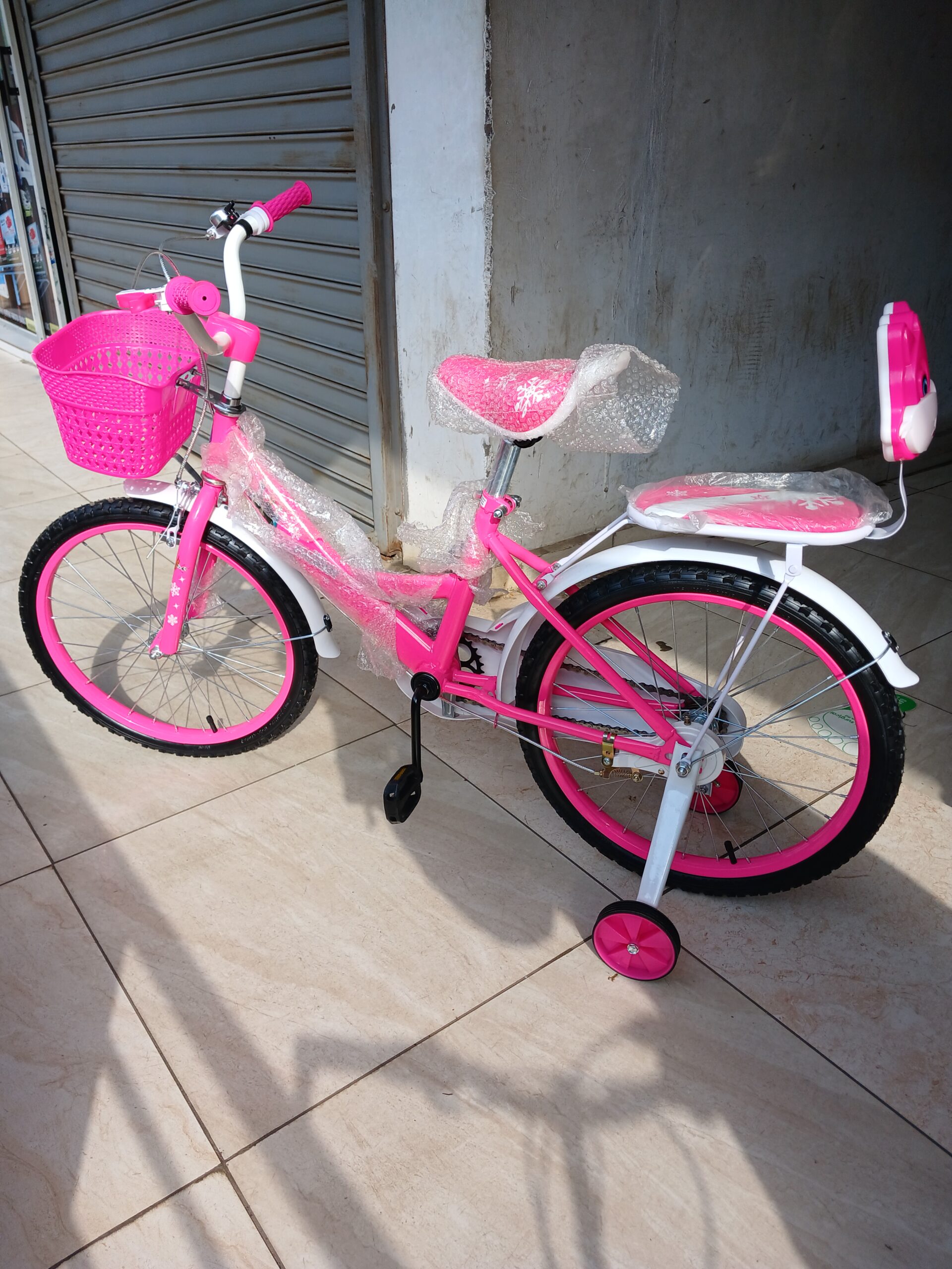 Frozen Size 20 Bike in pink with training wheels, front basket, rear child seat, bell and kickstand for children aged 6–10 years.